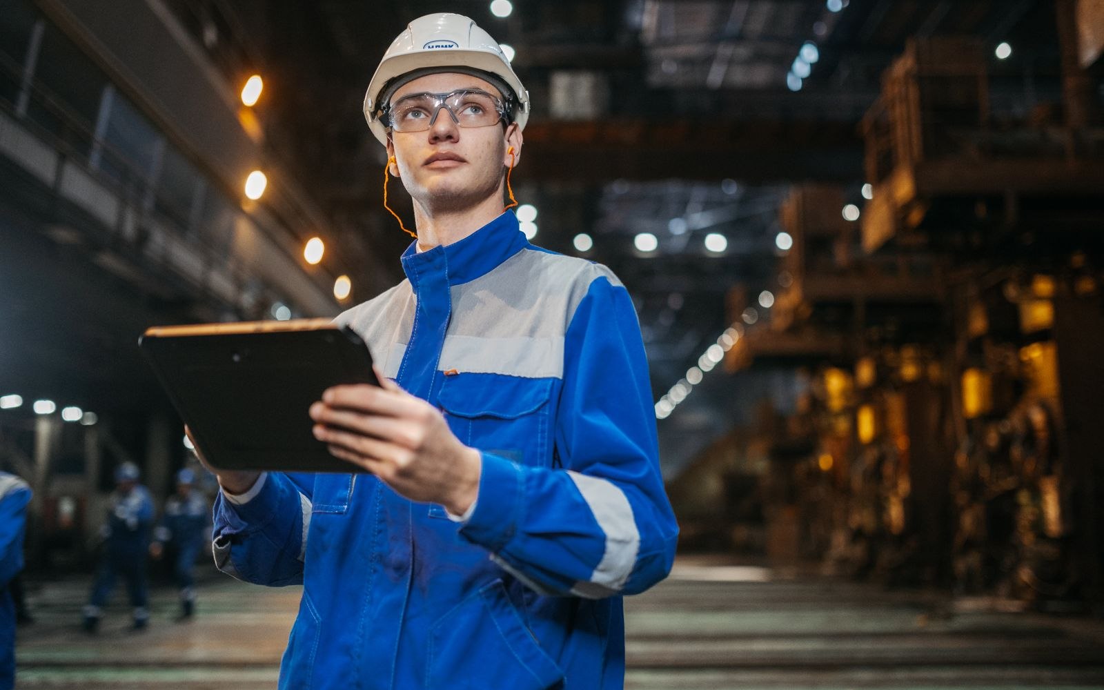 Factory worker checking a tablet in a steel plant