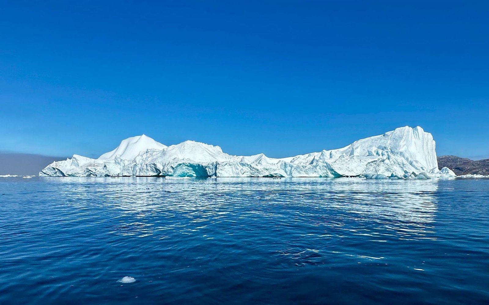 Iceberg on blue water: the visible tip is only a fraction of the total mass